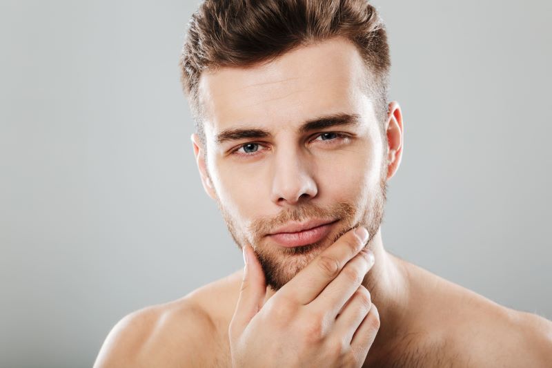 close up portrait young bearded man looking camera